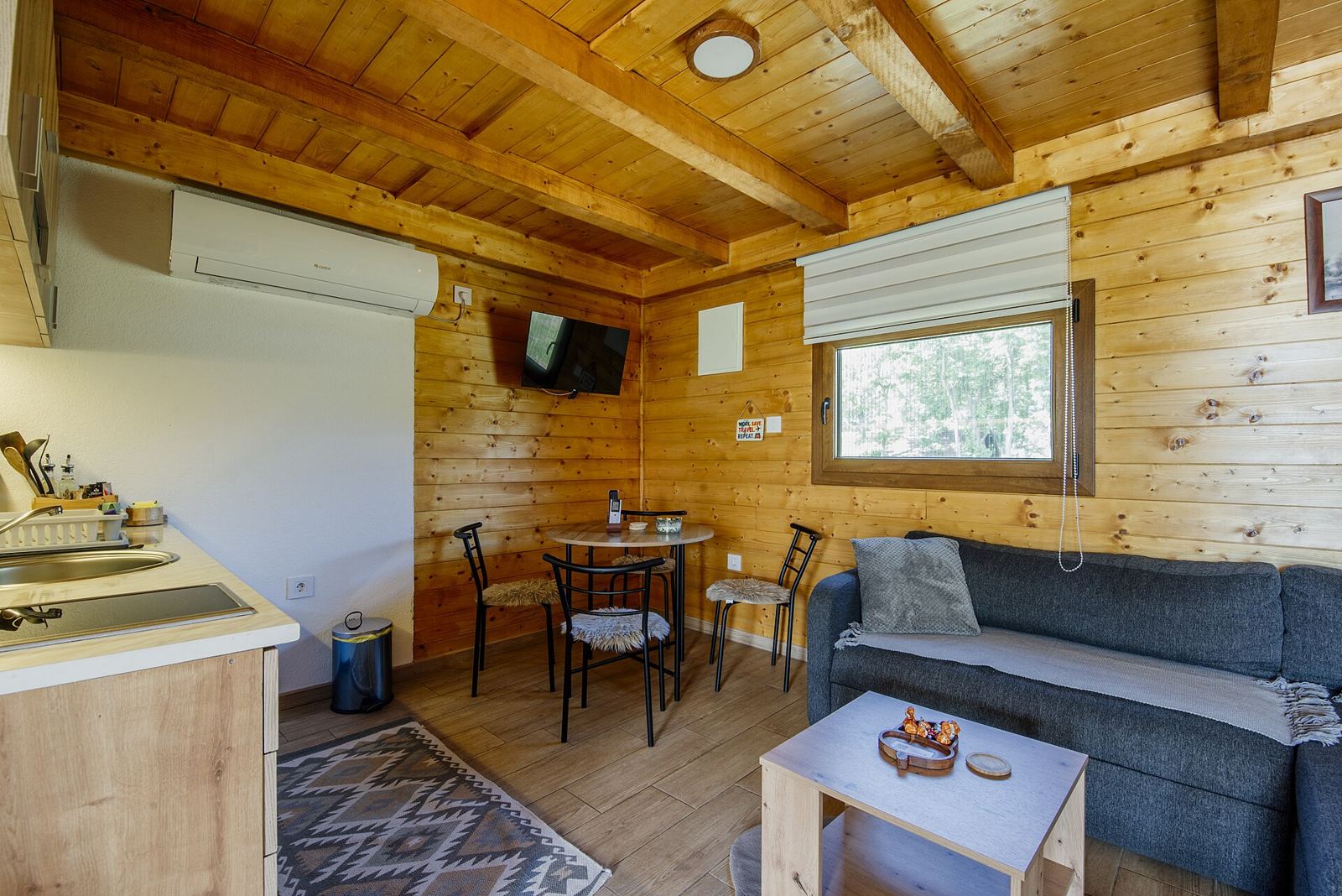 Cocina y comedor de madera con mesa junto a la ventana (foto de ejemplo)