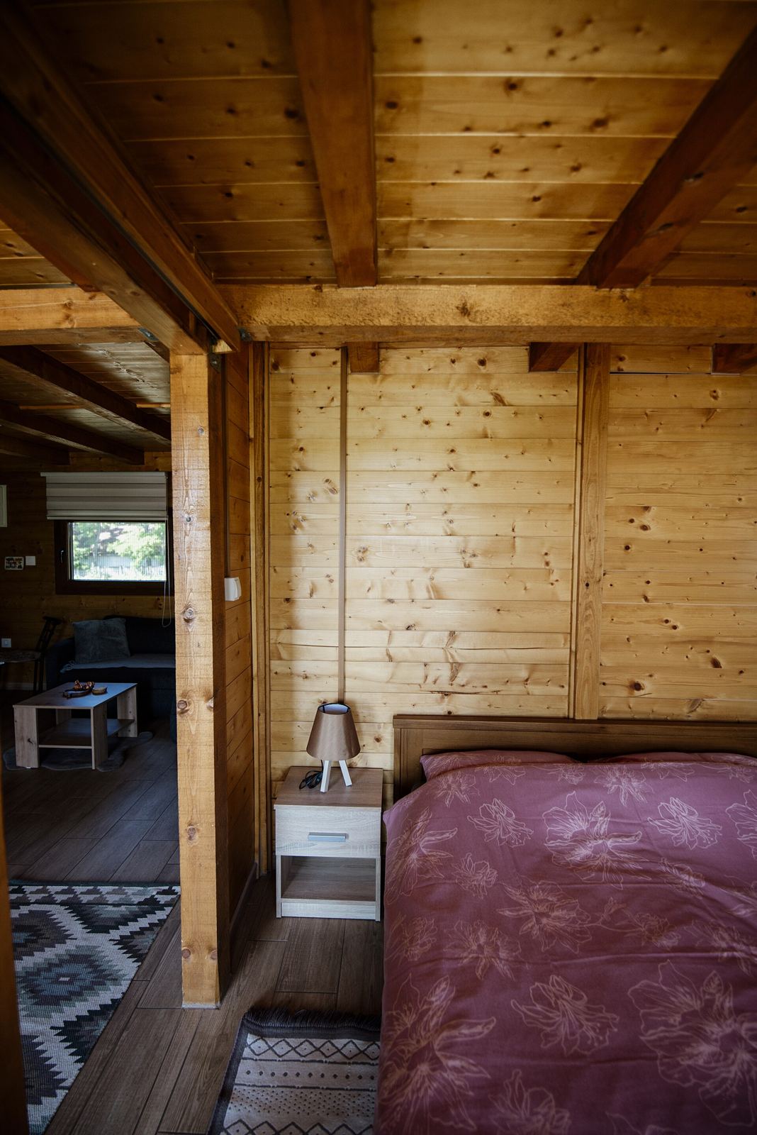 Dormitorio de madera con cama doble junto a la ventana (foto de ejemplo)